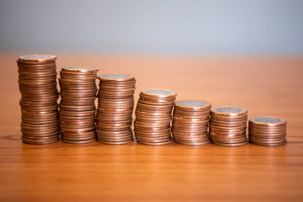 Рио-де-Жанейро (ЮАР), 30 / 10 / 2024 - ВСЕМИРНЫЙ ДЕНЬ САВИНГОВ - сложенные монеты на деревянном фоне стола