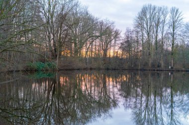 Dramatik bulutlu gökyüzü, gün batımında göl manzarası