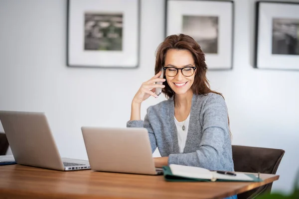 迷人的女人在家里工作时穿着眼镜和休闲装 女商人用手提电脑打电话 总部办公室 — 图库照片