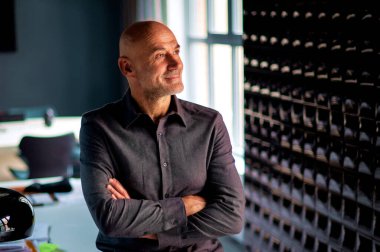 Ofiste kollarını kavuşturmuş orta yaşlı iş adamının portresi..