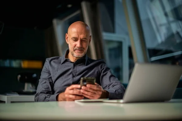 Közepes Felnőtt Üzletember Asztalnál Laptoppal Mobiltelefonnal Üzlettárs Szöveges Üzenetek Dolgozik — Stock Fotó