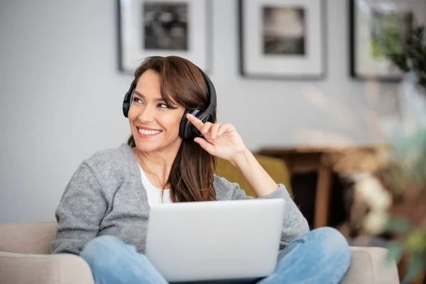 Close Pięknej Kobiety Średnim Wieku Słuchawkami Pomocą Laptopa Podczas Przeglądania — Zdjęcie stockowe