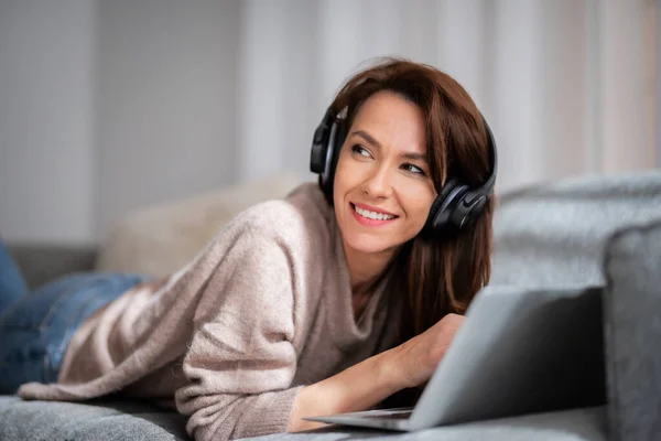 Schöne Frau Mittleren Alters Mit Kopfhörern Die Einen Laptop Benutzt — Stockfoto