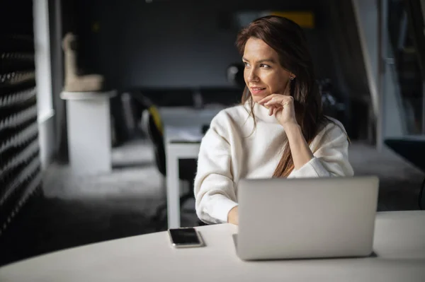 オフィスでデスクに座っている間 ラップトップを使用している中年のビジネス女性 セーターを着た実業家 — ストック写真