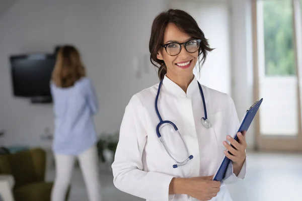 女医生穿着实验室外套和听诊器 手握剪贴板站在医院走廊 — 图库照片