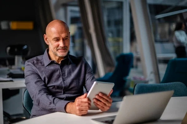 Geschäftsmann Mit Tablet Und Laptop Während Einem Modernen Büro Sitzt — Stockfoto