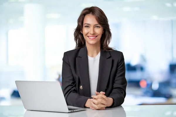 迷人的女商人穿着西装 工作时使用笔记本电脑 微笑的女性看着相机笑着 — 图库照片