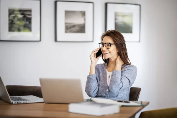 快乐的女人工作时使用手机和笔记本电脑 有信心的女商人在家里工作 总部办公室 — 图库照片