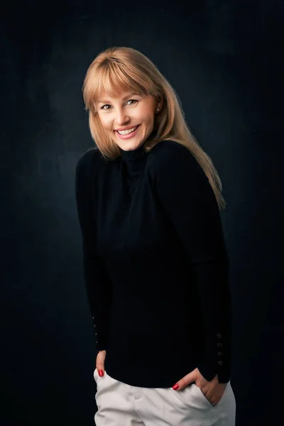 孤立した暗い背景に立って美しい笑顔の女性 タートルネックのセーターを着たブロンドの髪の女性 スペースのコピー — ストック写真