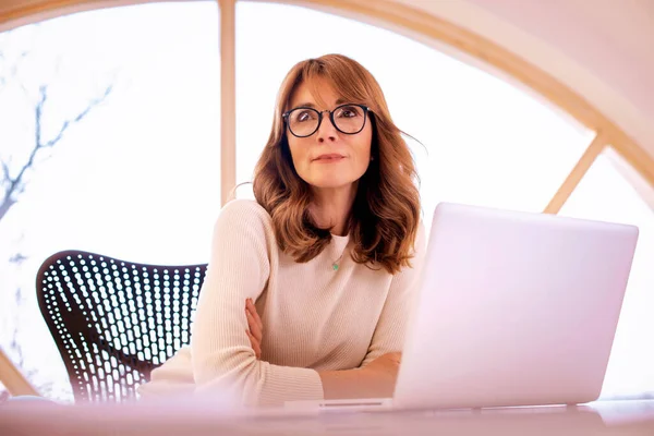 Orta Yaşlı Bir Kadınının Ofiste Dizüstü Bilgisayarla Oturup Düşünceli Bir — Stok fotoğraf