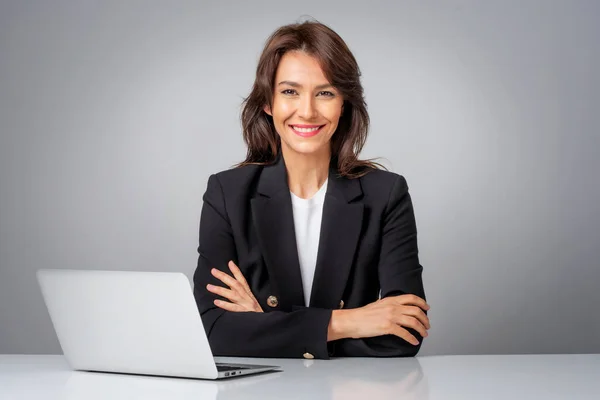 仕事のためにラップトップを使用して魅力的なビジネスマンのスタジオショット 独立した灰色の背景に座って笑顔の女性 スペースのコピー — ストック写真