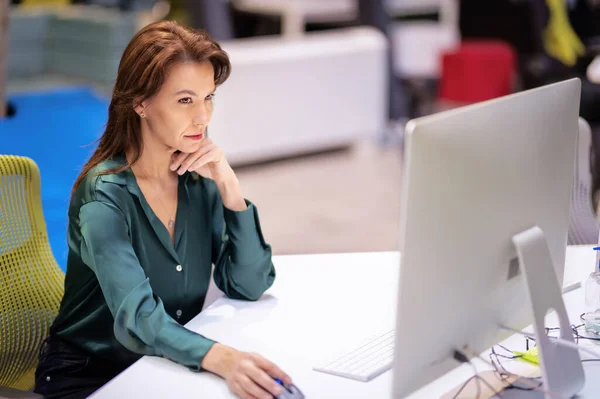 オフィスでデスクに座っている間 コンピュータを使用している中年のビジネス女性 新しいビジネスプロジェクトで働くプロの女性 — ストック写真