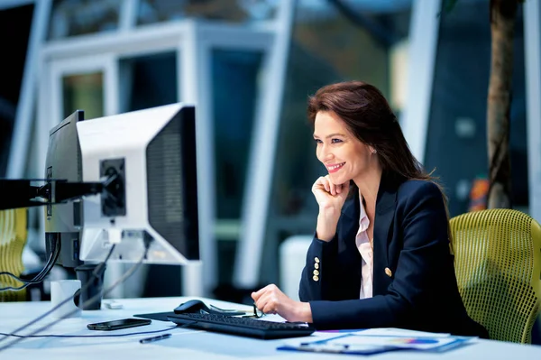 中年女商人坐在办公室的办公桌前 一边用电脑 从事新商业项目的专业女性 — 图库照片