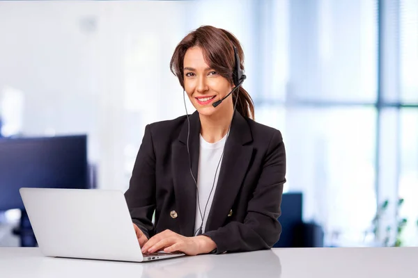 Ofiste Bilgisayar Başında Çalışan Kulaklık Takan Çekici Bir Kadınının Fotoğrafı — Stok fotoğraf