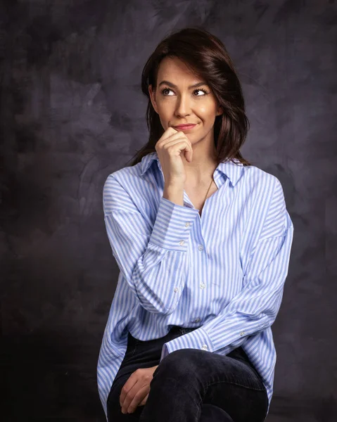 Usměvavá Brunetka Sedící Tmavém Pozadí Jistá Profesionálka Sobě Modrou Košili — Stock fotografie
