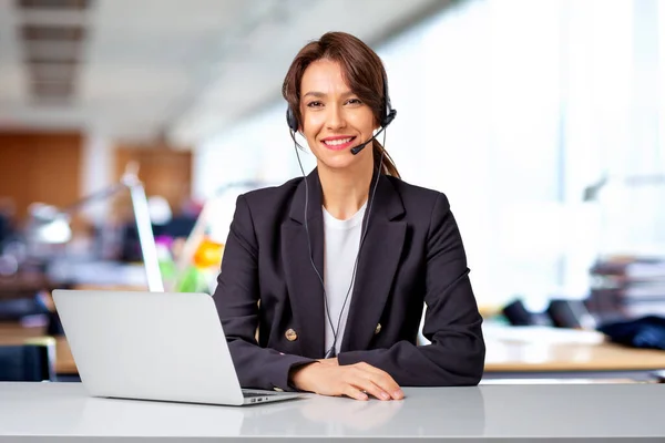 客户服务助理坐在电脑前 头戴耳机 在呼叫中心工作 穿着黑色西装的有魅力的女商人 — 图库照片