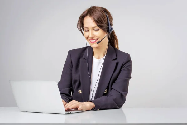Strzał Atrakcyjnej Bizneswoman Noszącej Słuchawki Podczas Pracy Przy Komputerze Odizolowane — Zdjęcie stockowe