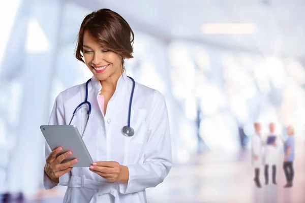 病院の廊下に立っている間 彼女の患者チャートをデジタルタブレットで保持している女性医師の肖像画 — ストック写真