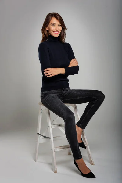 의자에 매력적 여자가 터틀넥 스웨터를 바지를 전체적으로 촬영됐다 — 스톡 사진