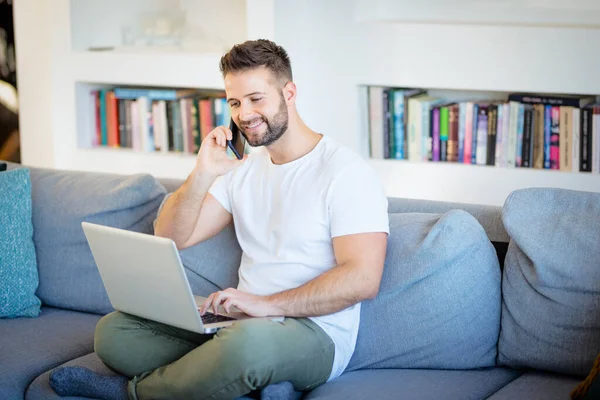 Schöner Mann Mit Handy Und Laptop Für Die Arbeit Hause — Stockfoto