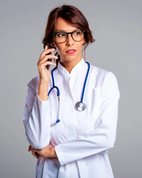 Retrato Doctora Pensante Usando Teléfono Móvil Hablando Fondo Gris Aislado — Foto de Stock