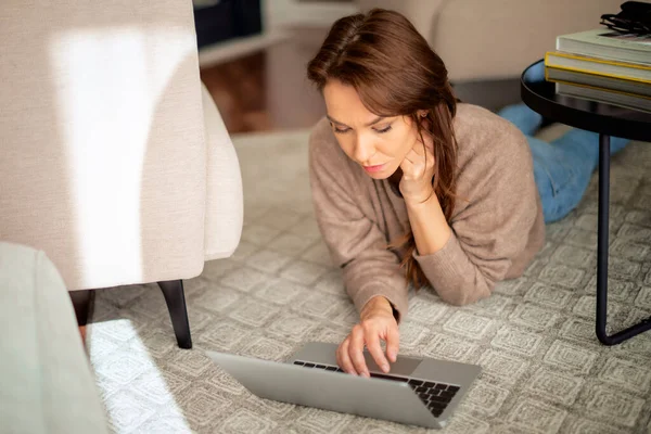 Mulher Meia Idade Atraente Deitada Chão Casa Enquanto Usa Laptop — Fotografia de Stock