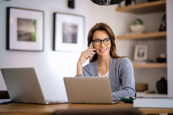 Lycklig Kvinna Som Använder Mobiltelefon Och Bärbara Datorer För Arbete — Stockfoto