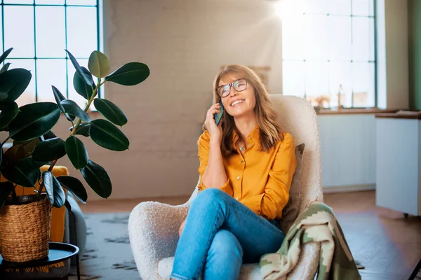 Портрет Счастливой Зрелой Женщины Разговаривающей Кем Мобильному Телефону Отдыхающей Дома — стоковое фото
