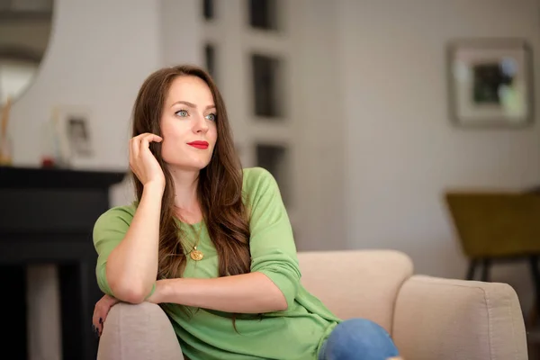 집에서 의자에서 휴식을 취하면서 캐주얼 여자의 초상화 립스틱과 스웨터를 매력적인 — 스톡 사진