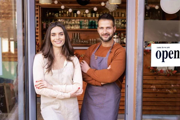 小さなビジネスオーナーの女性と男がカフェのドアに立っている — ストック写真