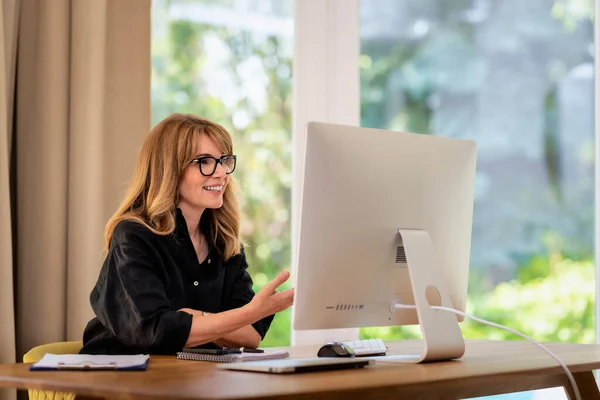 中年妇女坐在办公桌前 开网络会议 有信心的女商人使用计算机在家里工作 总部办公室 — 图库照片
