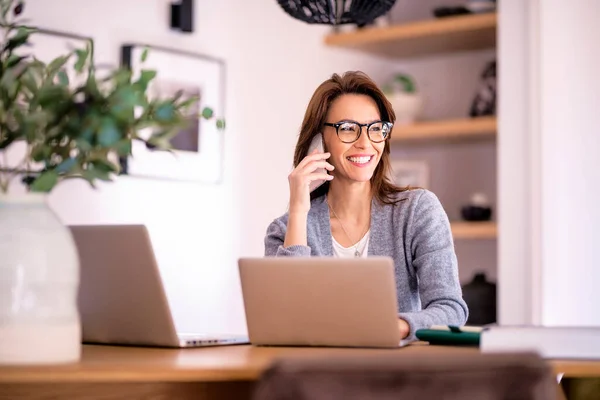 迷人的女人在家里工作时穿着眼镜和休闲装 女商人用手提电脑打电话 总部办公室 — 图库照片