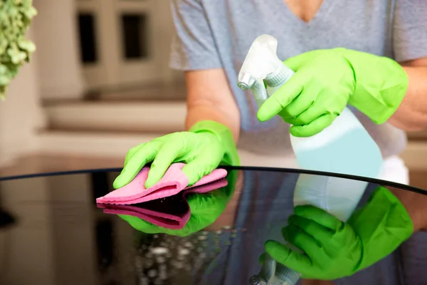 집에서 테이블을 여자의 클로즈업 장갑을 착용하고 집에서 청소하는 청소를 사용하는 스톡 사진