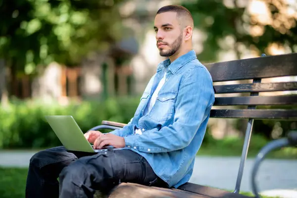 옥외에서 공부하거나 일하기 노트북을 사용하는 젊은이 캐주얼 공원에서 벤치에 — 스톡 사진