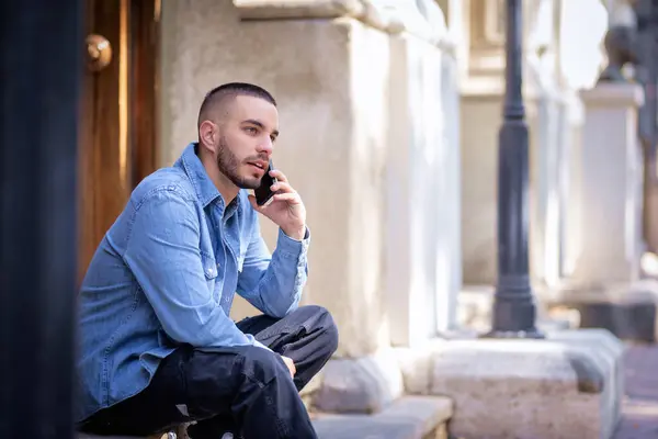 Beskuren Bild Stilig Ung Man Som Använder Sin Mobiltelefon När — Stockfoto