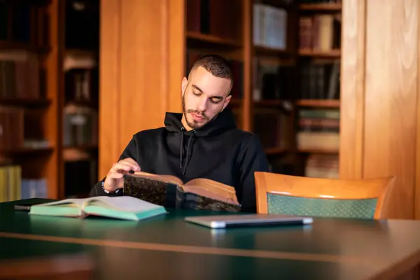 Joven Sentado Biblioteca Universitaria Aprendiendo Hombre Guapo Usando Sudadera Con —  Fotos de Stock