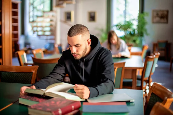 Junger Mann Sitzt Der Universitätsbibliothek Und Lernt Schöner Mann Trägt — Stockfoto