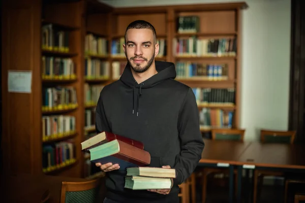 Молодий Чоловік Стоїть Університетській Бібліотеці Тримає Руках Книжки Красивий Чоловік — стокове фото