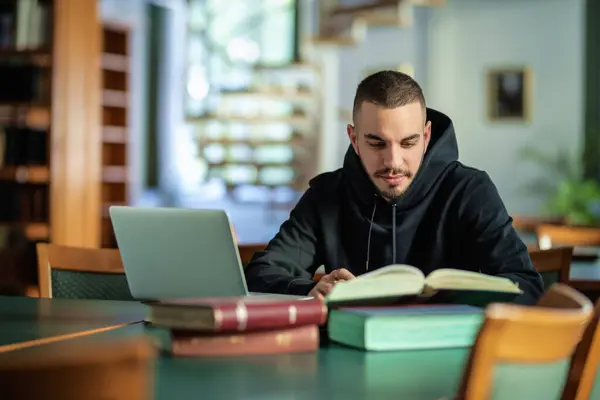 Уверенный Молодой Человек Сидит Университетской Библиотеке Учится Кавказский Студент Помощью Стоковая Картинка