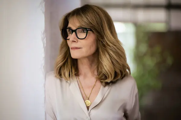 Stock image Portrait of a beautiful middle-aged woman standing at the wall. Brunette haired female wearing shirt and eyewear and looking thoughtfully. Copy space.