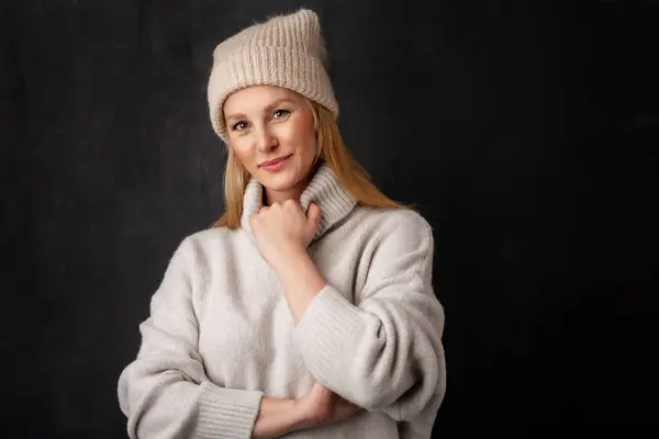 孤立した暗い背景に立って美しい笑顔の女性 ニット帽とタートルネックセーターを着てブロンドの髪の女性 スペースのコピー — ストック写真