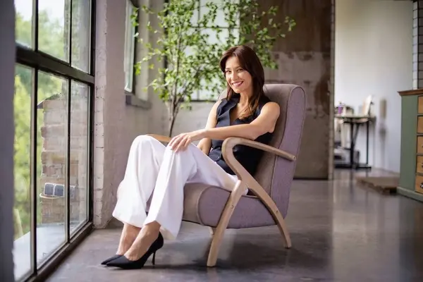 의자에서 휴식을 취하는 아름다운 여성의 초상화 셔츠와 바지를 매력적인 로열티 프리 스톡 이미지