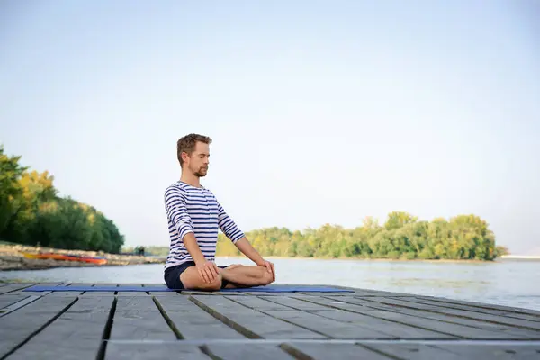 全长的高加索男人在一个又一个的码头上做瑜伽 成熟男人练习莲花姿势 放松身心 — 图库照片
