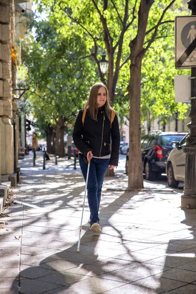 路上で歩いている白い杖を持つ盲目の女性の肖像画 視覚障害のある女性がカジュアルな服を着て 道を渡るために杖を使った 全長ショット — ストック写真