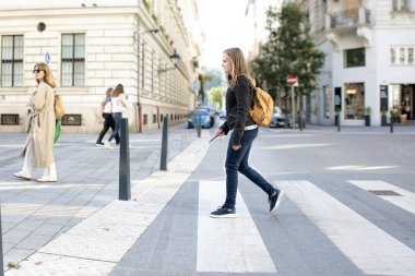 Şehirde yoldan karşıya geçen beyaz bastonlu kör bir kadının portresi. Sıradan kıyafetler giyen ve sopasıyla karşıya geçen görme engelli bir kadın. Tam boy çekim.