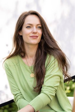 Güneşe karşı gülümseyen güzel bir genç kadın. Fiziksel ve zihinsel sağlık dengesi ve refahı. Yaşam tarzı kavramları. Çekici genç kadın yeşil gözlü ve uzun esmer saçlı..