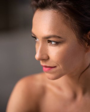 Esmer, orta yaşlı, gülümseyen ve içine bakan bir kadının vesikalığı.. 