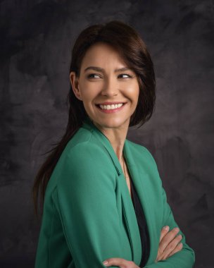 Güzel esmer bir kadının portresi izole bir arka planda oturuyor. Ceket giyen orta yaşlı bir kadın. Boşluğu kopyala.