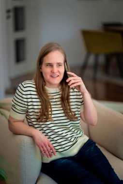 Görme engelli bir kadın koltuğunda oturmuş telefonda biriyle konuşuyor.. 