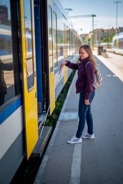 Şehrin dışındaki tren istasyonunda duran beyaz bastonlu kör kadın portresi. Görme engelli bir kadın trene biniyor. Günlük kıyafetler. Tam uzunluk. 